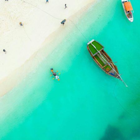 Boats and people on Zanzibar ocean shore